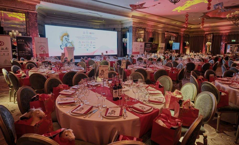 The ballroom laid with round tables in front of the stage screen