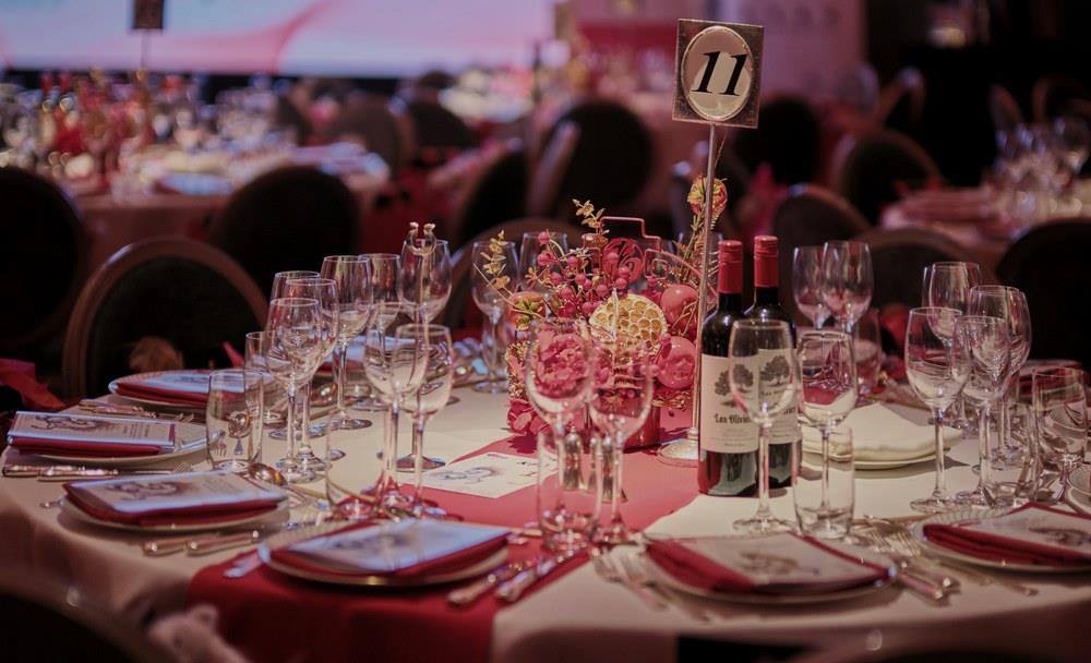 A table laid for twelve with flowers, wine and a table number